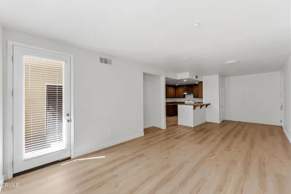 a view of a kitchen with wooden floor and windows