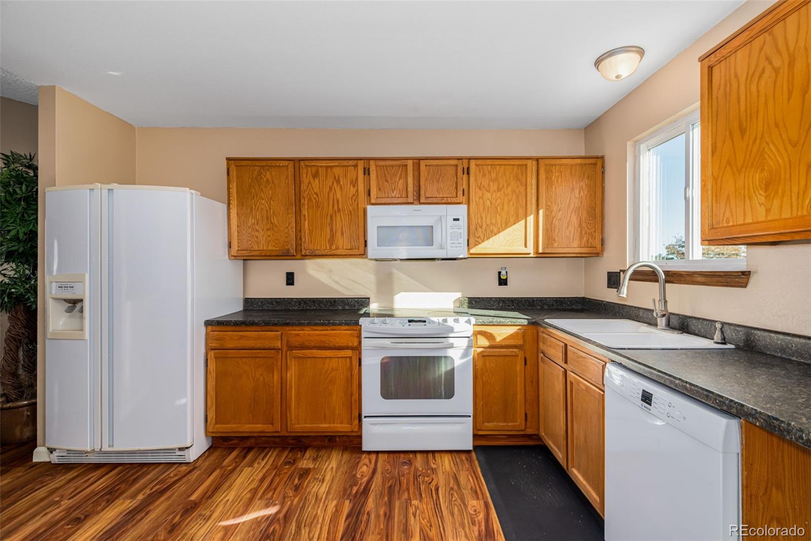 12260 Magnolia Way Brighton, CO 80602 - Photo 7 of 30 a kitchen with a stove a sink and a refrigerator