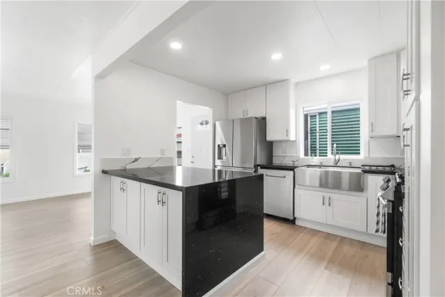 a kitchen with stainless steel appliances granite countertop a stove a sink and a refrigerator