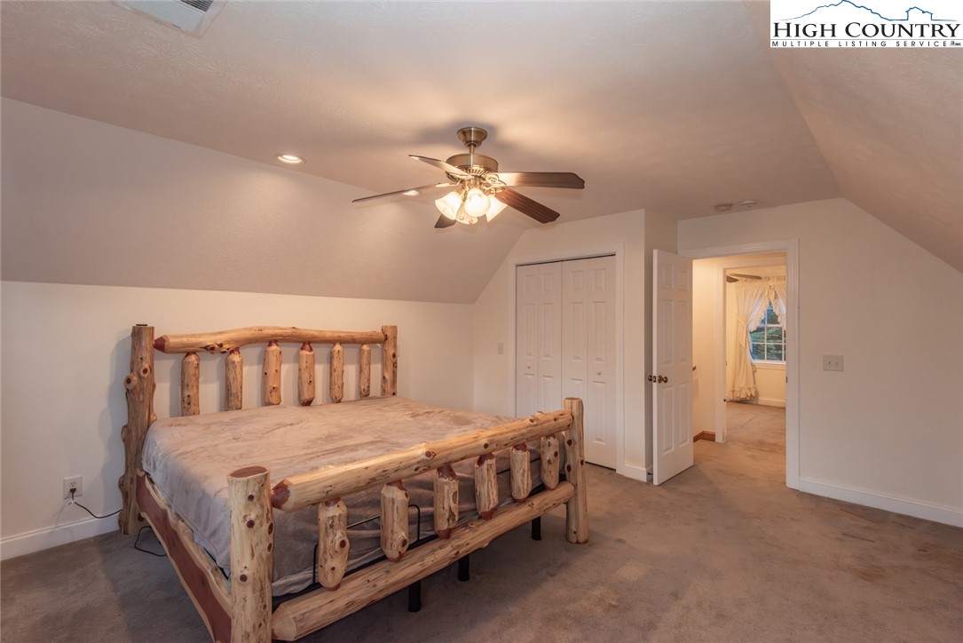 1195 Long Branch Road Lansing, NC 28643 - Photo 15 of 31 a bedroom with a large bed and a chandelier