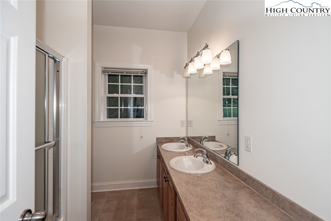 1195 Long Branch Road Lansing, NC 28643 - Photo 18 of 31 a bathroom with a granite countertop sink and a mirror