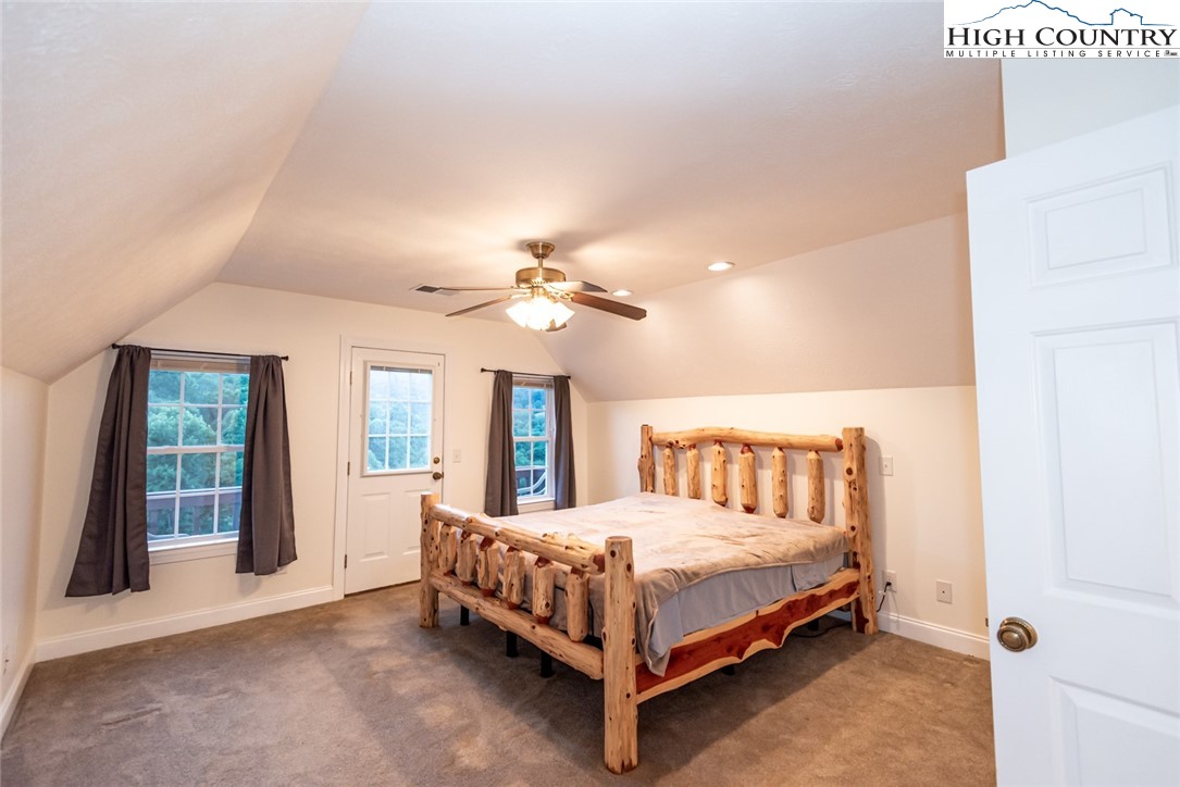 1195 Long Branch Road Lansing, NC 28643 - Photo 25 of 31 a bedroom with a large bed and a chandelier