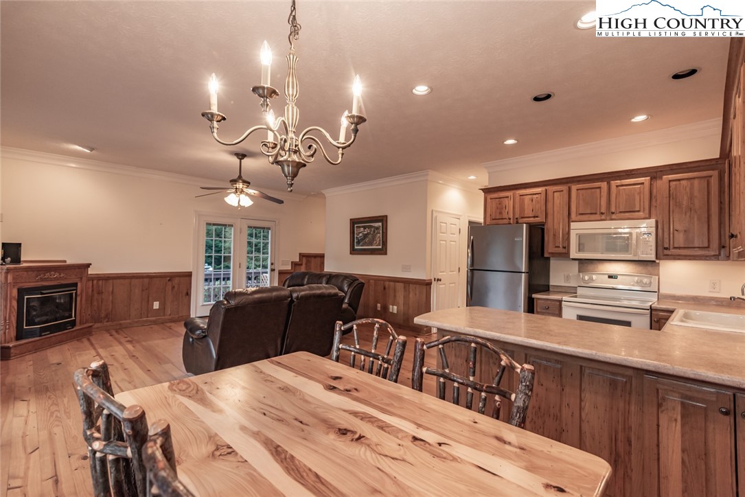 1195 Long Branch Road Lansing, NC 28643 - Photo 8 of 31 a kitchen with stainless steel appliances kitchen island granite countertop a refrigerator a stove a sink dishwasher and a dining table with the living room