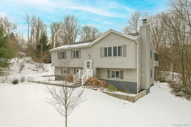 a view of house with yard and sitting area