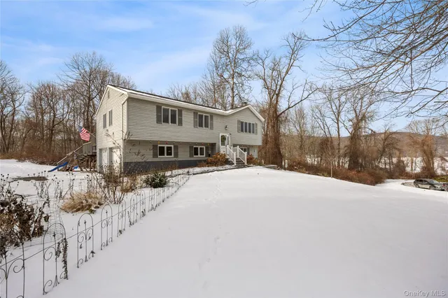 a front view of a house with a yard covered in snow