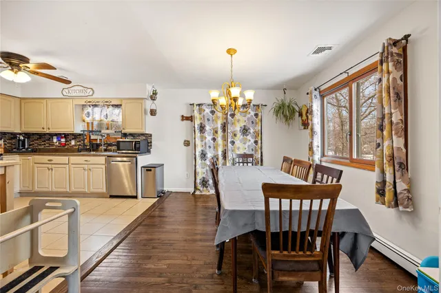 a kitchen with stainless steel appliances granite countertop a stove a sink dishwasher a dining table and chairs with wooden floor