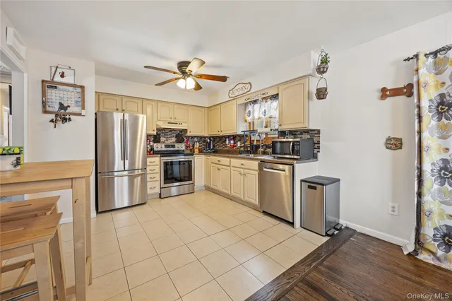 a kitchen with a stove a refrigerator and white cabinets