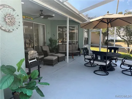 a view of a patio with a table and chairs under an umbrella