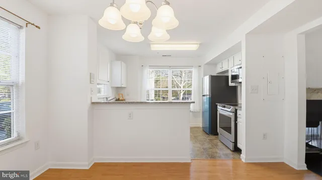 a kitchen with granite countertop white cabinets and a window