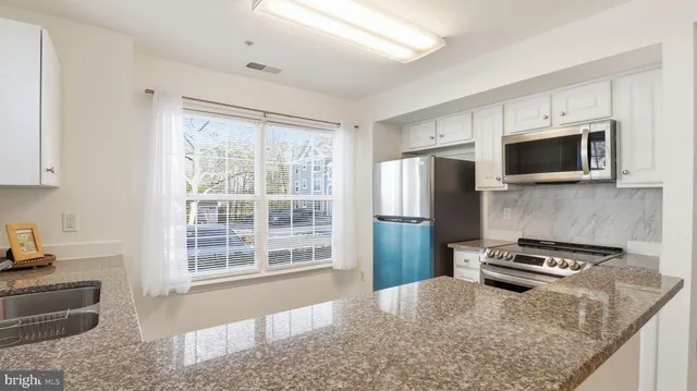 a kitchen with granite countertop a stove oven and sink
