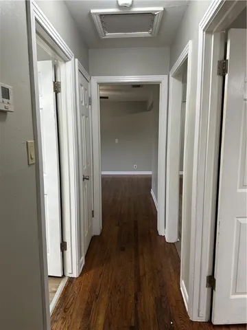 a view of a hallway with wooden floor and staircase