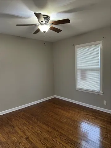 a view of wooden floor and a chandelier fan in a room