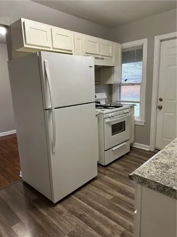 a white refrigerator freezer and a wooden floor