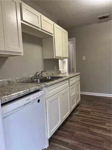 a kitchen with granite countertop white cabinets and white appliances