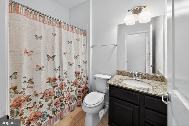 a view of a room with wooden floor and a ceiling fan