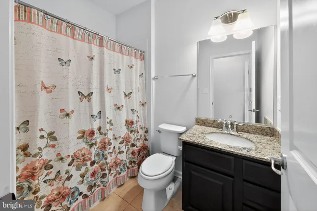 a view of a room with wooden floor and a ceiling fan