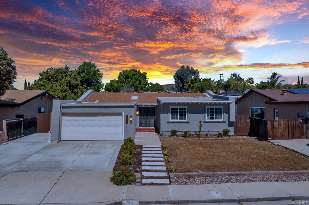 a front view of a house with a yard and potted plants