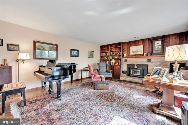 a living room with furniture a fireplace and a large window