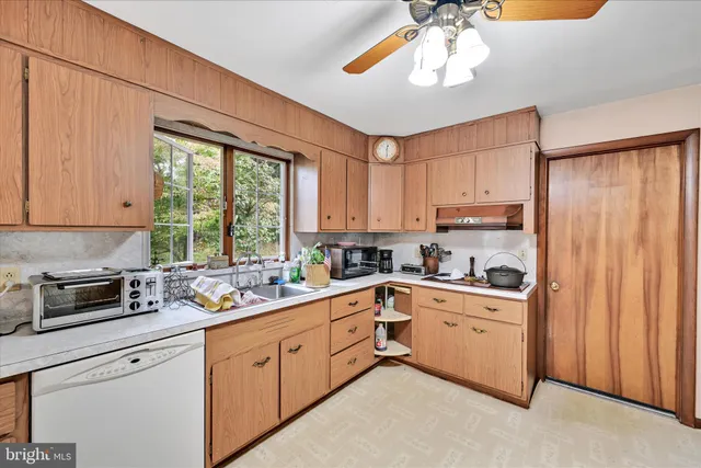 a kitchen with a sink cabinets stainless steel appliances and a window