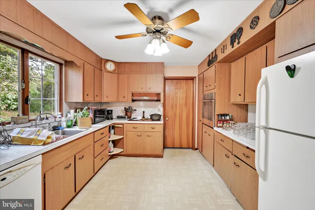 a kitchen with cabinets stainless steel appliances a sink and a large window