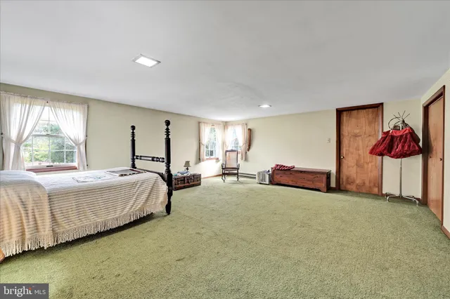 a spacious bedroom with a bed and lamp