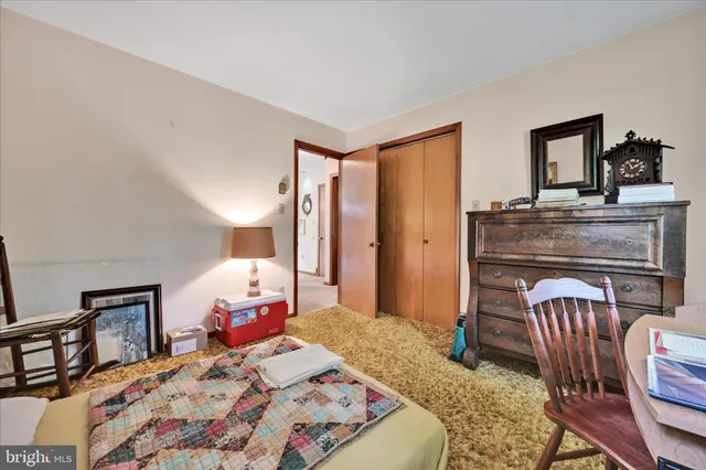 a bedroom with a bed a dresser next to a window