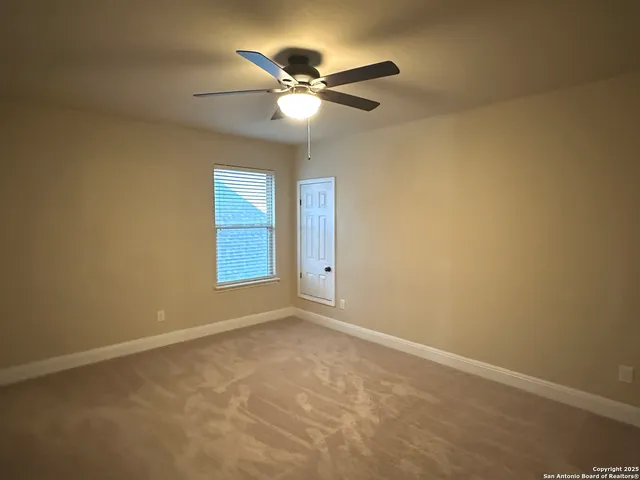 a view of an empty room with a ceiling fan