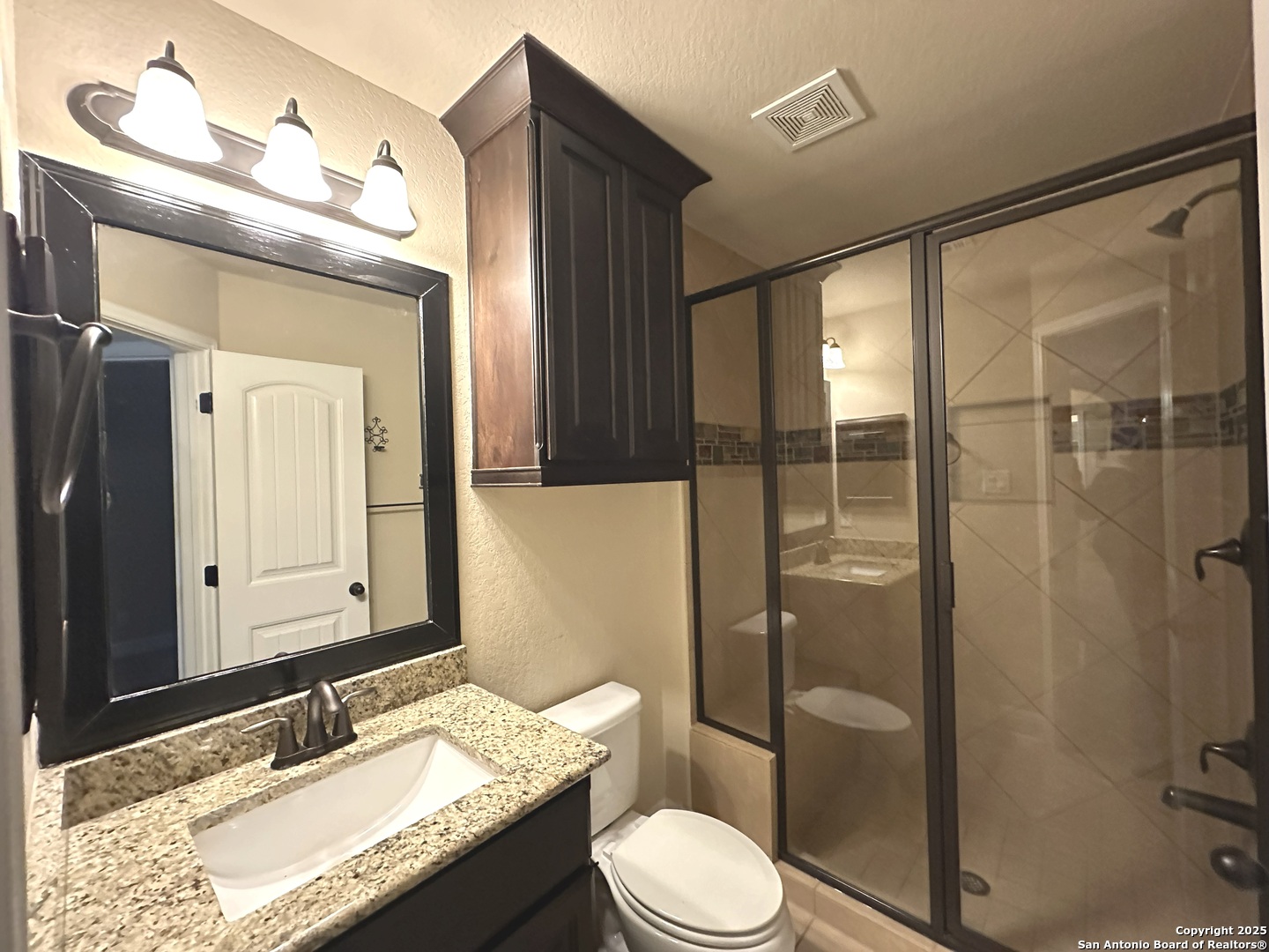 24507 Chianti Way San Antonio, TX 78260 - Photo 23 of 26 a bathroom with a granite countertop sink toilet mirror and shower