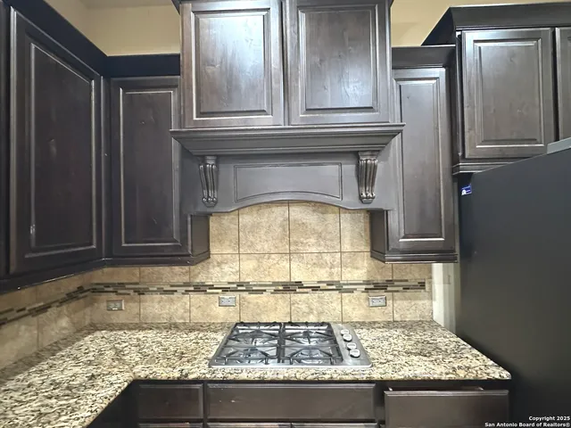 a kitchen with granite countertop a stove and a sink