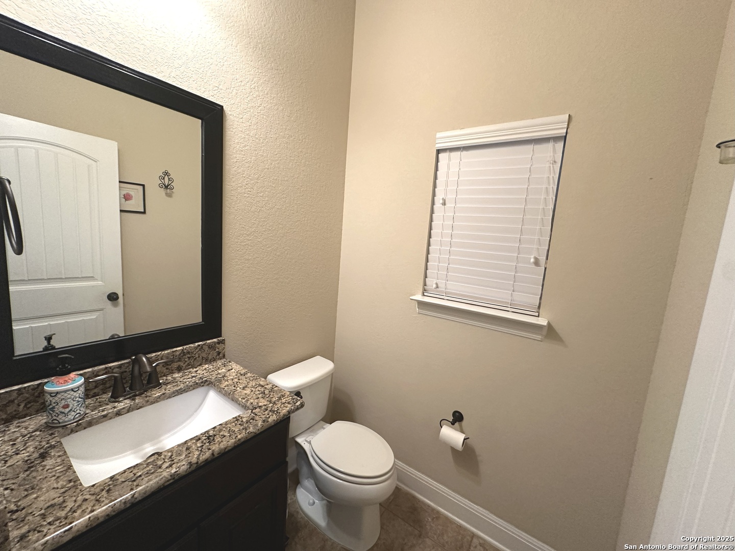 24507 Chianti Way San Antonio, TX 78260 - Photo 10 of 26 a bathroom with a granite countertop toilet a sink and a mirror