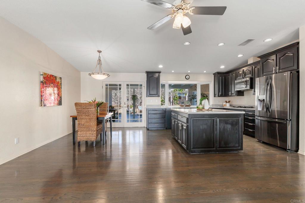 3326 Monroe Street Carlsbad, CA 92008 - Photo 11 of 63 a kitchen with stainless steel appliances kitchen island granite countertop a table chairs and a refrigerator