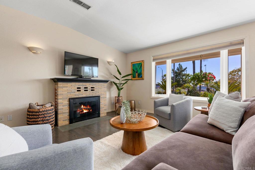 3326 Monroe Street Carlsbad, CA 92008 - Photo 7 of 63 a living room with furniture a flat screen tv and a fireplace