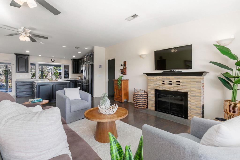 3326 Monroe Street Carlsbad, CA 92008 - Photo 8 of 63 a living room with furniture a fireplace and a flat screen tv
