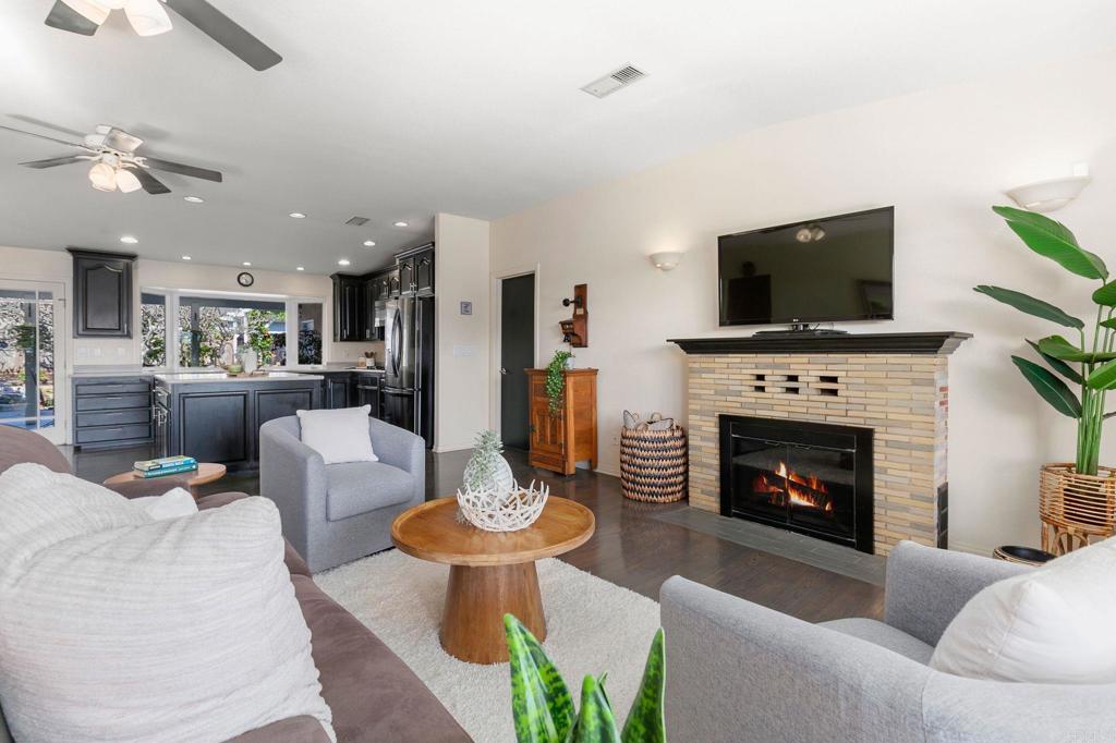 3326 Monroe Street Carlsbad, CA 92008 - Photo 9 of 63 a living room with furniture a flat screen tv and a fireplace