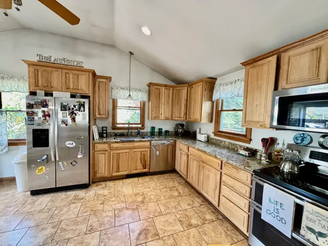 a kitchen with stainless steel appliances granite countertop a refrigerator stove top oven a sink and dishwasher