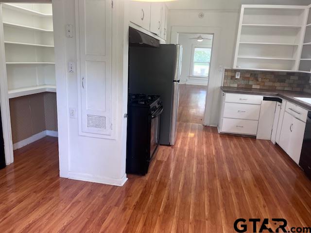 617 West Dobbs Street Tyler, TX 75701 - Photo 11 of 19 a kitchen with white cabinets and wooden floor