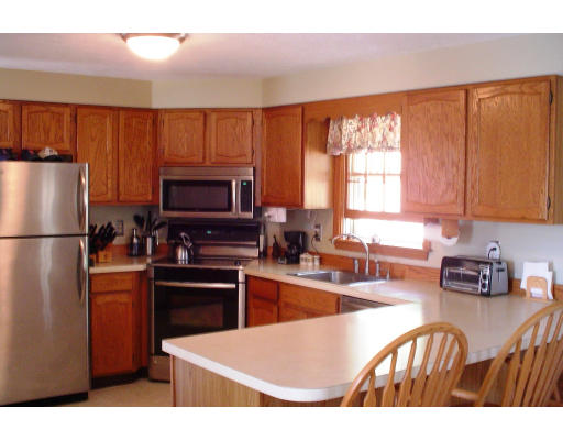 22 Wallace Road Groton, MA 01450 - Photo 2 of 5 a kitchen with stainless steel appliances granite countertop a refrigerator a stove top oven a sink and dishwasher
