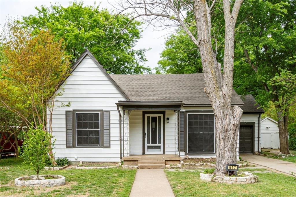 a view of a house with a yard and large tree