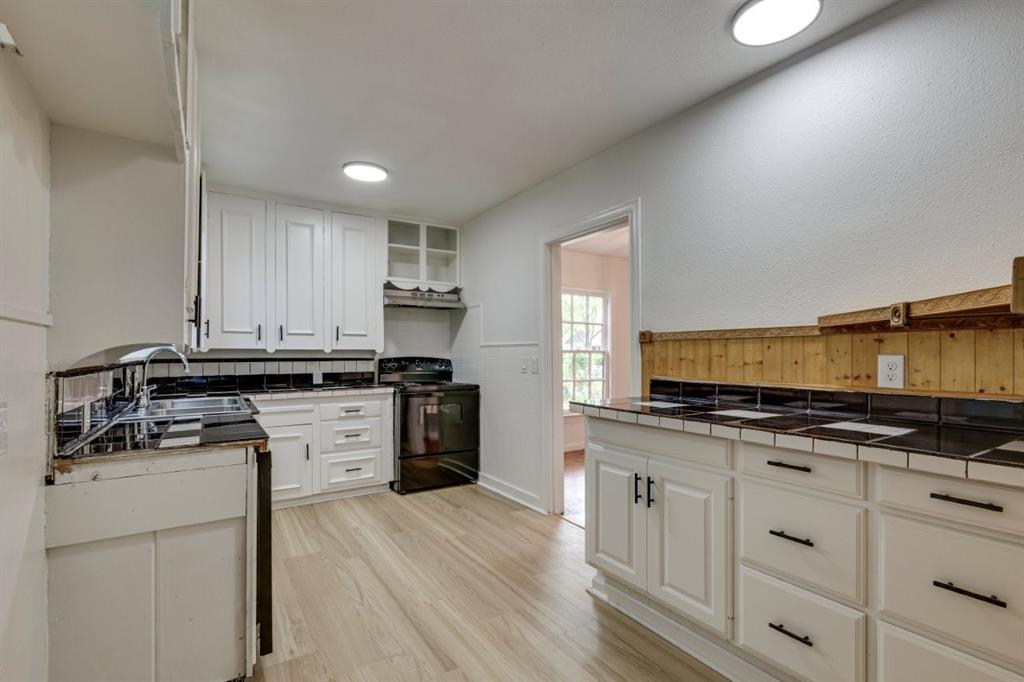 617 Wilson Street Lancaster, TX 75146 - Photo 14 of 30 a kitchen with stainless steel appliances granite countertop a stove a sink and a microwave