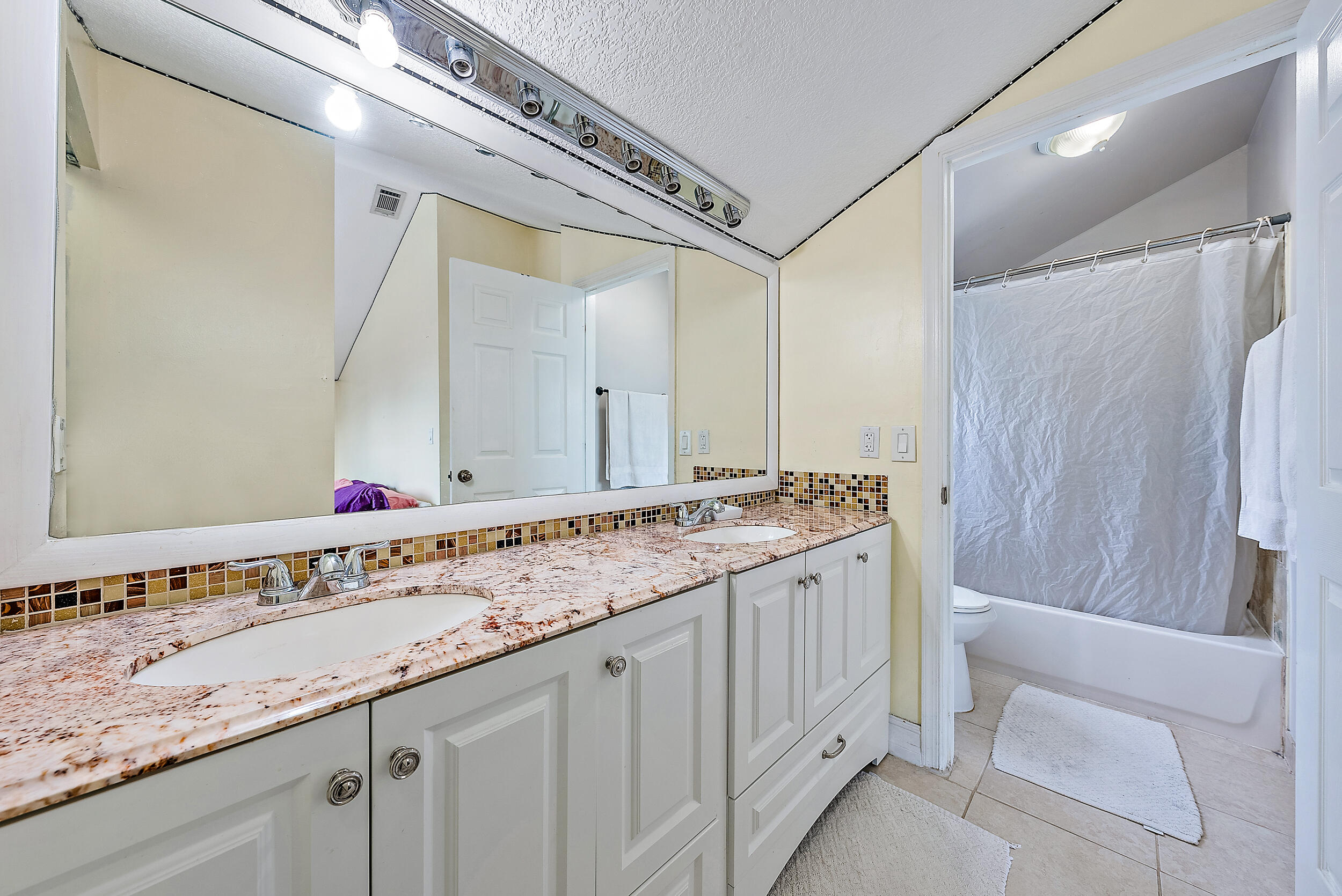 5872 Rambler Rose Way West Palm Beach, FL 33415 - Photo 17 of 30 a bathroom with a sink and a mirror