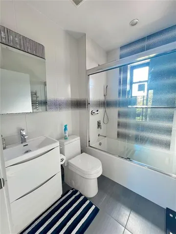 a bathroom with a sink toilet vanity and shower