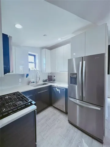 a kitchen with refrigerator a stove a sink and a window