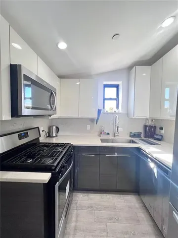 a kitchen with stainless steel appliances a sink stove and cabinets