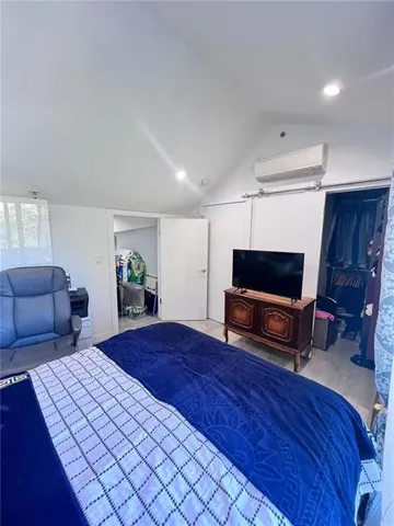 a bedroom with a bed and a television