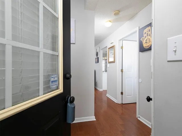 a view of a hallway with wooden floor and windows