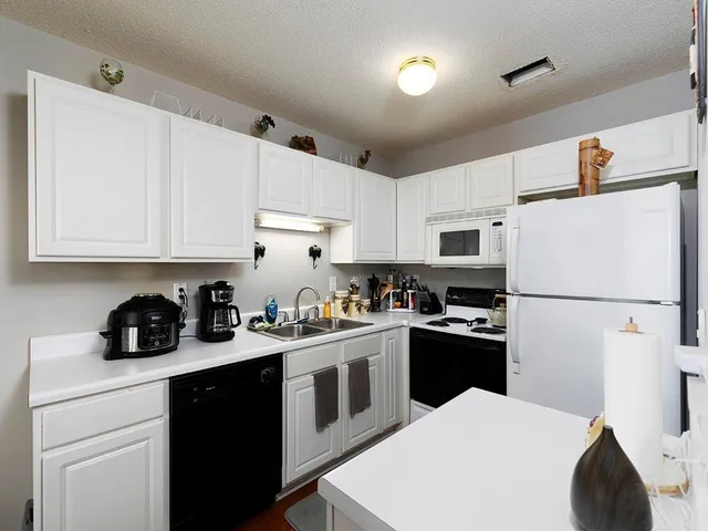 a kitchen with a white cabinets and white appliances