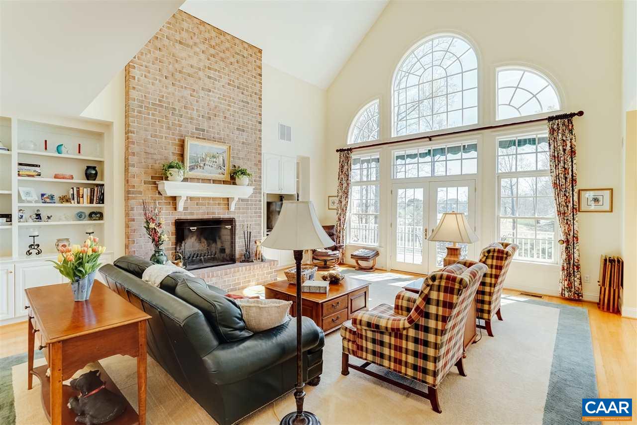 3159 Darby Road Keswick, VA 22947 - Photo 9 of 50 a living room with furniture a fireplace and a floor to ceiling window