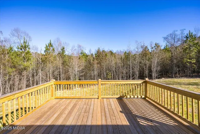 a view of a balcony with wooden floor and with trees