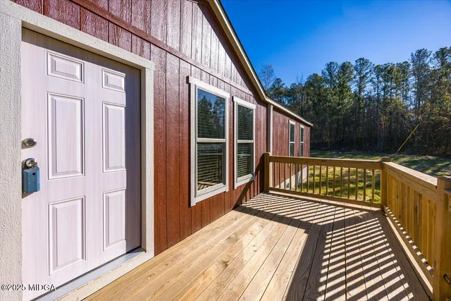 a view of a balcony with wooden floor and fence