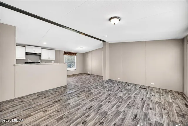 a view of empty room with wooden floor